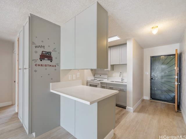 kitchen with white range with electric stovetop, light hardwood / wood-style flooring, kitchen peninsula, and a textured ceiling