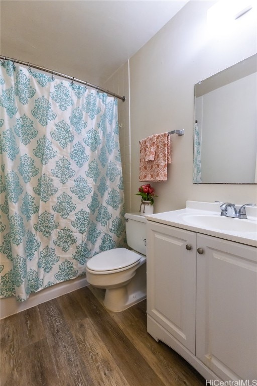 bathroom featuring vanity, toilet, curtained shower, and hardwood / wood-style floors