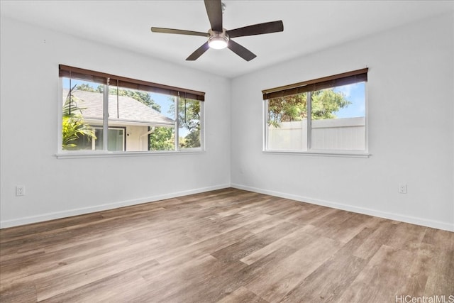 spare room with a wealth of natural light, light hardwood / wood-style flooring, and ceiling fan