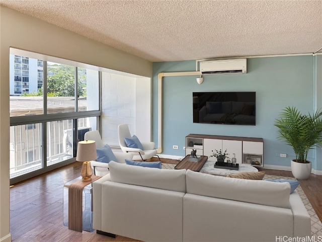 living room featuring a textured ceiling, a wall mounted AC, and hardwood / wood-style flooring