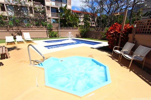 view of pool with a hot tub and a patio area