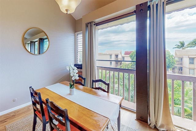 dining space featuring light hardwood / wood-style flooring and lofted ceiling