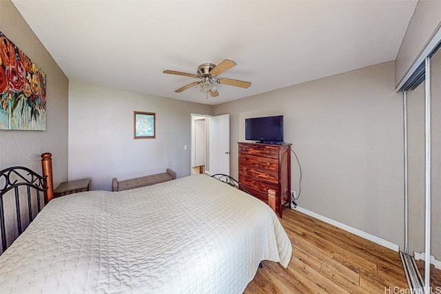 bedroom with a closet, light hardwood / wood-style floors, and ceiling fan