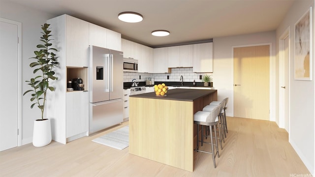 2599 Kapiolani Blvd Unit 312, Honolulu, HI 96826 - kitchen featuring a kitchen bar, dark countertops, appliances with stainless steel finishes, and light wood finished floors