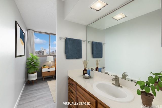 bathroom featuring wood finished floors, vanity, and baseboards