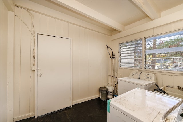 laundry area with independent washer and dryer and wooden walls