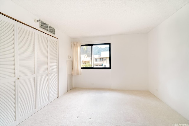 unfurnished bedroom with a closet, visible vents, and carpet floors