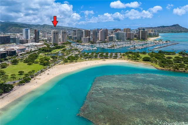 view of swimming pool with a water and mountain view, a view of the beach, and a city view