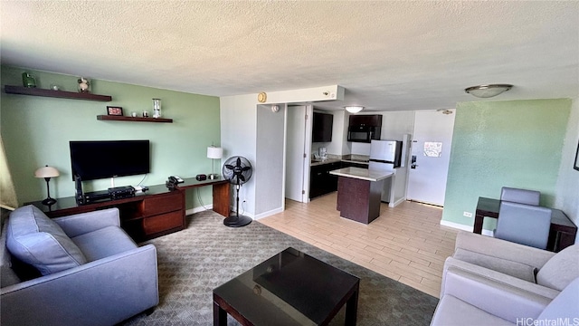 living room featuring light hardwood / wood-style flooring and a textured ceiling