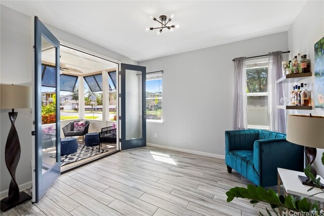 living area featuring a notable chandelier and light hardwood / wood-style floors