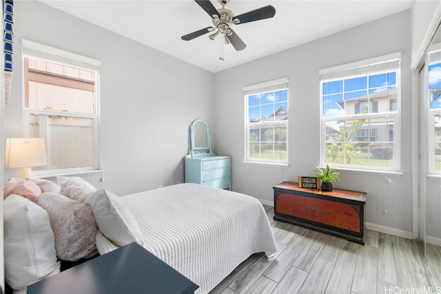 bedroom featuring multiple windows, wood-type flooring, and ceiling fan