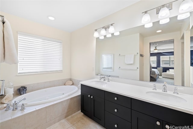 bathroom with vanity, a relaxing tiled tub, and tile patterned flooring