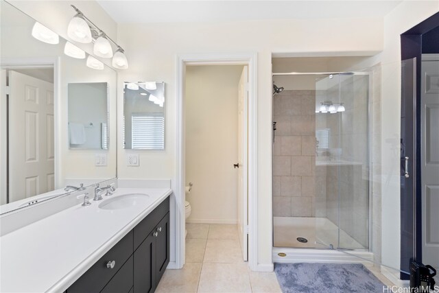 bathroom with vanity, tile patterned flooring, toilet, and an enclosed shower