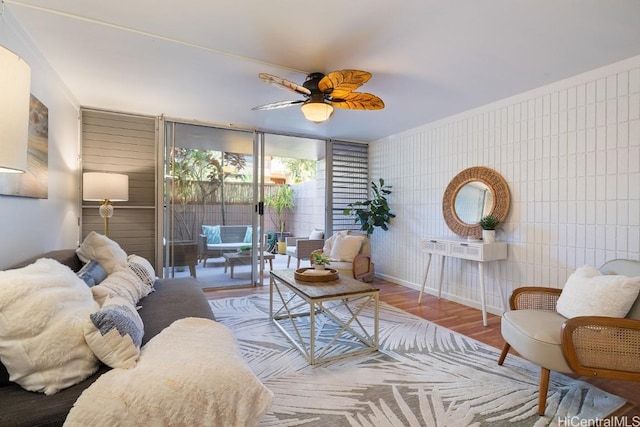 living room featuring ceiling fan, tile walls, and hardwood / wood-style flooring