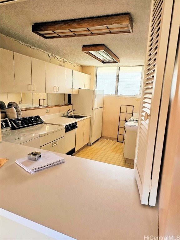 kitchen with white cabinetry, a textured ceiling, separate washer and dryer, sink, and white appliances