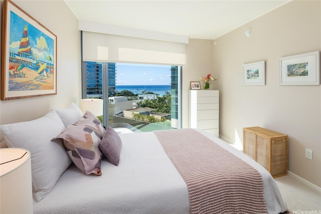 carpeted bedroom with baseboards and a water view
