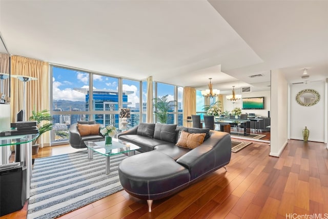 living room featuring an inviting chandelier, hardwood / wood-style floors, and floor to ceiling windows