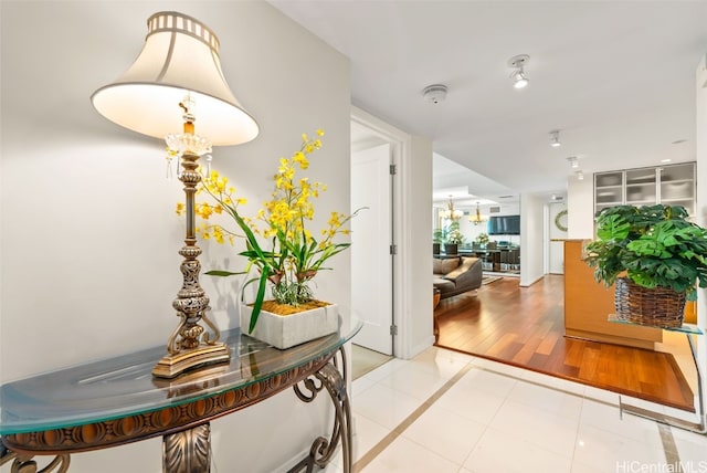 corridor featuring a chandelier and light tile patterned flooring