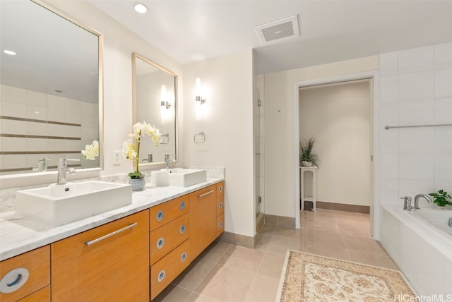 bathroom featuring tile patterned flooring, vanity, and a tub