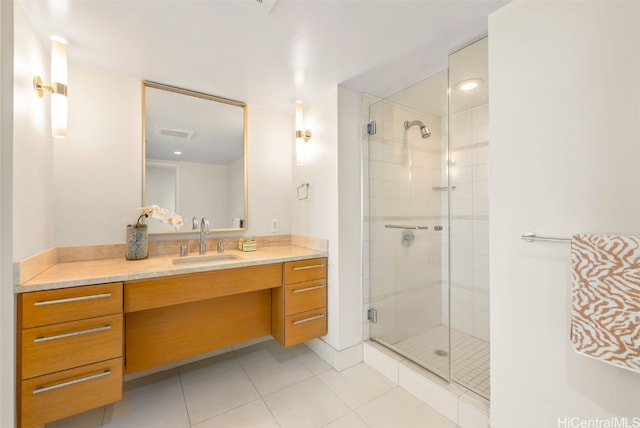 bathroom with vanity, a shower with shower door, and tile patterned floors