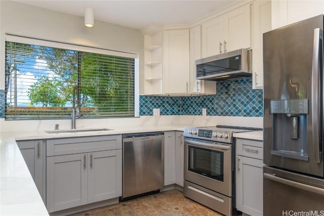 kitchen with open shelves, stainless steel appliances, tasteful backsplash, white cabinetry, and a sink