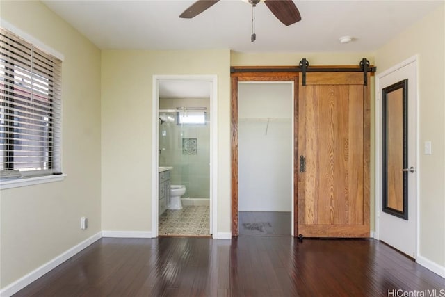 unfurnished bedroom with dark wood-style floors, a closet, baseboards, and a ceiling fan