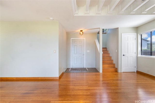 foyer with stairs, baseboards, and wood finished floors