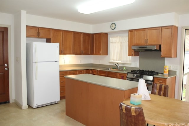 kitchen featuring stainless steel range with gas stovetop, sink, a center island, and white fridge