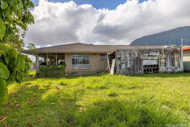 back of property with a yard and a mountain view