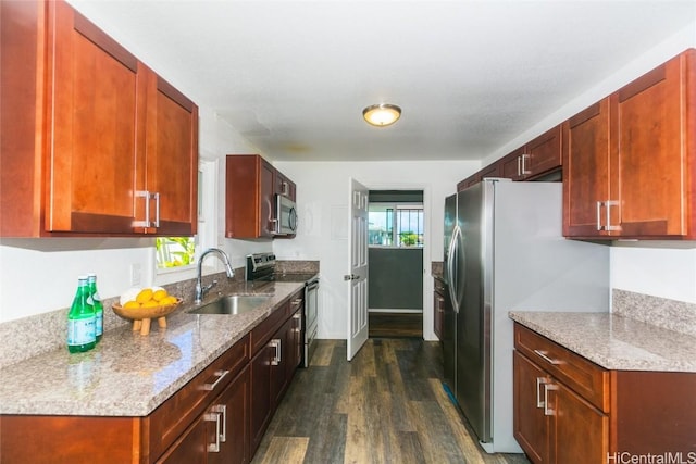 kitchen featuring light stone counters, sink, dark hardwood / wood-style floors, and appliances with stainless steel finishes