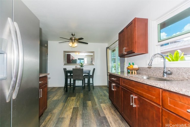 kitchen with sink, stainless steel fridge, ceiling fan, light stone counters, and dark hardwood / wood-style flooring