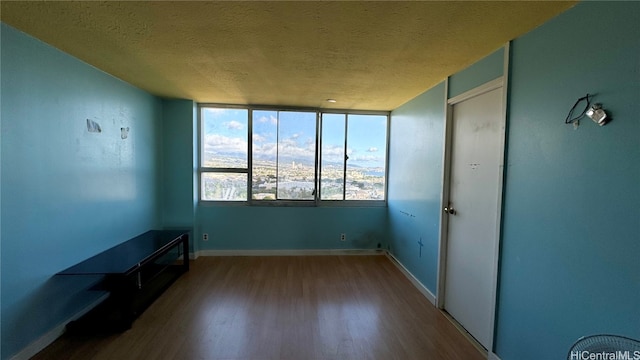 spare room featuring hardwood / wood-style flooring and a textured ceiling