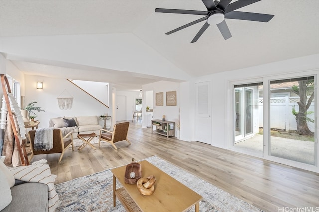 living room featuring ceiling fan, light wood-type flooring, and lofted ceiling