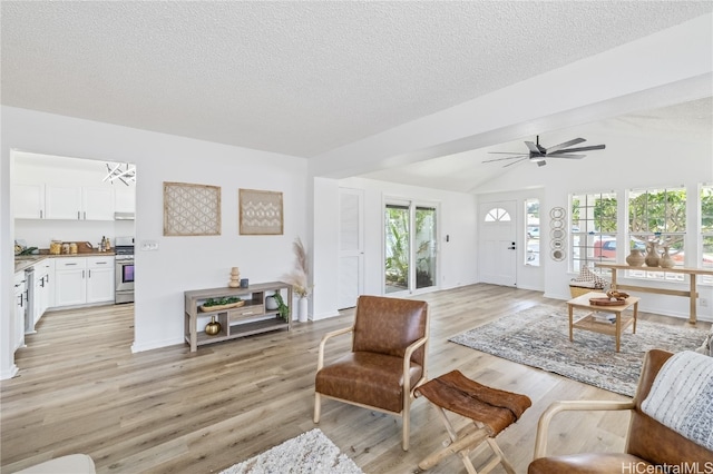 living room featuring ceiling fan, light wood-type flooring, a textured ceiling, and vaulted ceiling