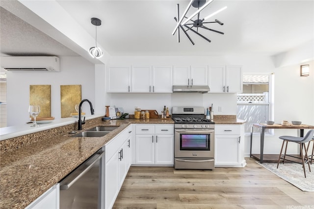 kitchen with a sink, stainless steel appliances, white cabinetry, under cabinet range hood, and a wall unit AC