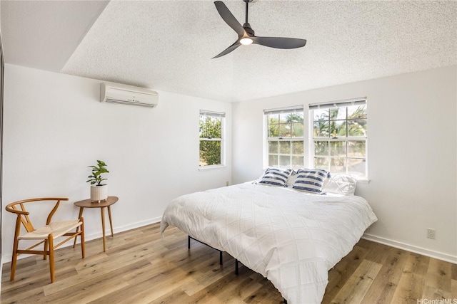 91-1019 Hiluhilu St, Kapolei, HI 96707 - bedroom featuring a wall mounted AC, light wood finished floors, a textured ceiling, baseboards, and a ceiling fan