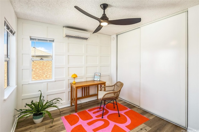 91-1019 Hiluhilu St, Kapolei, HI 96707 - sitting room with a wall mounted AC, a ceiling fan, a decorative wall, wood finished floors, and a textured ceiling