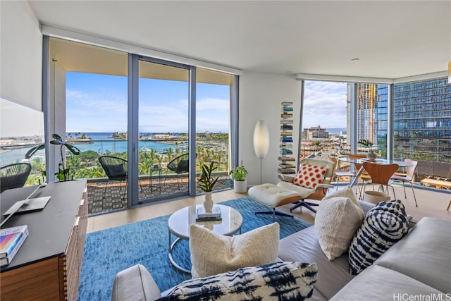 living room with a water view, a wall of windows, hardwood / wood-style flooring, and plenty of natural light