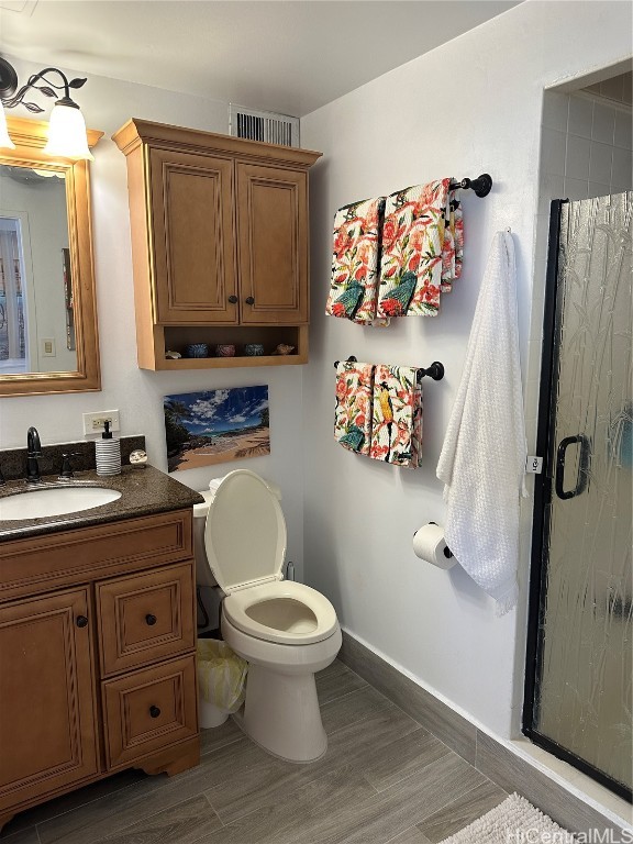 bathroom with a shower with door, vanity, wood-type flooring, and toilet