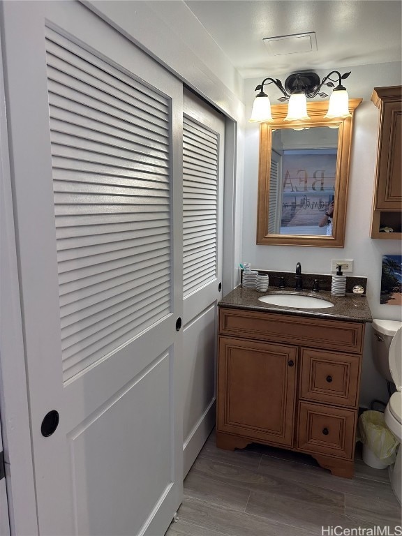 bathroom featuring vanity, toilet, and hardwood / wood-style flooring