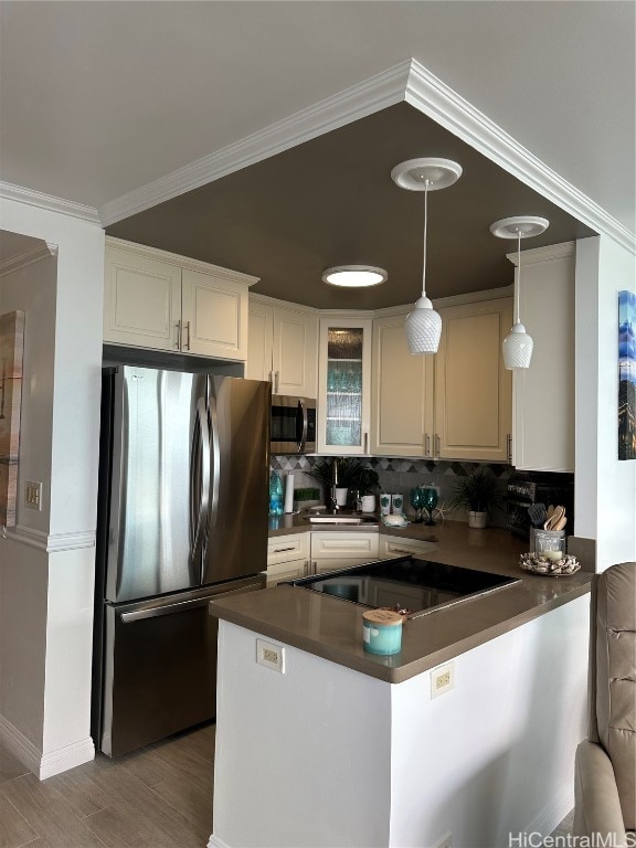 kitchen featuring appliances with stainless steel finishes, backsplash, kitchen peninsula, white cabinetry, and pendant lighting