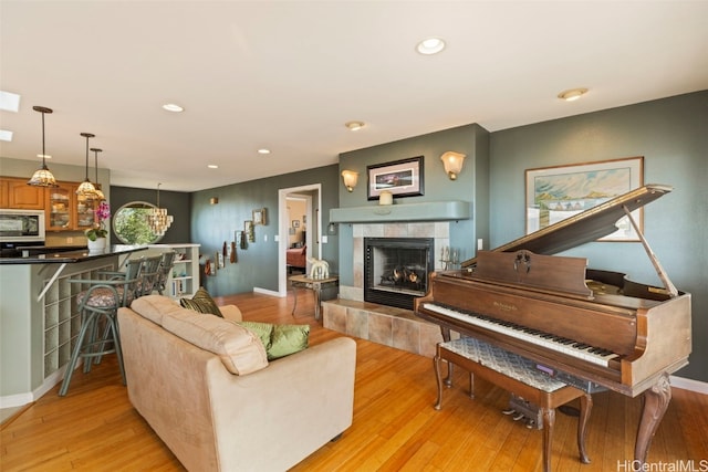 living room with a fireplace, light wood-type flooring, and a notable chandelier