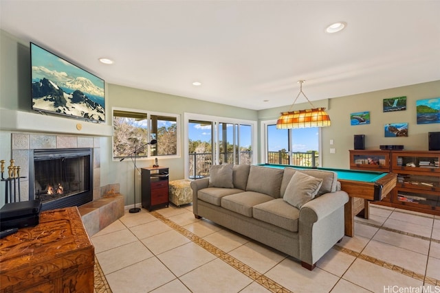 living room featuring light tile patterned floors, a tile fireplace, and billiards