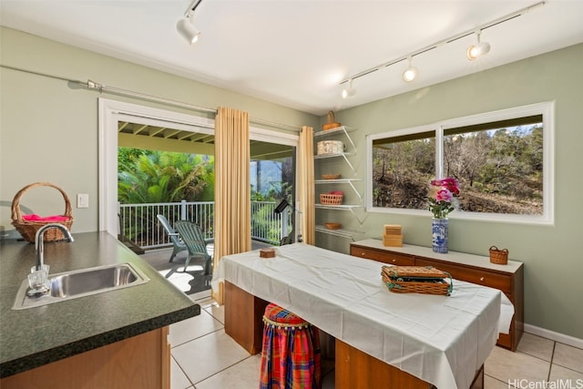 dining space featuring sink, light tile patterned floors, and track lighting