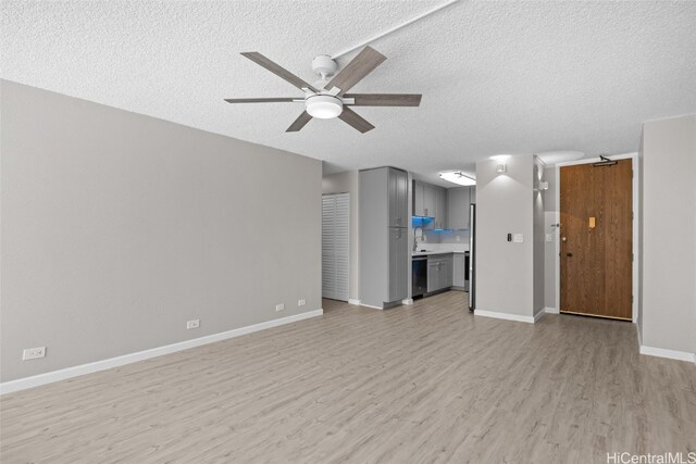 unfurnished living room featuring light hardwood / wood-style flooring, a textured ceiling, and ceiling fan