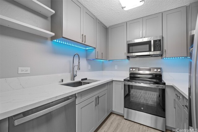 kitchen with gray cabinets, sink, appliances with stainless steel finishes, and a textured ceiling