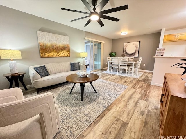 living room featuring ceiling fan and light hardwood / wood-style flooring