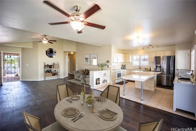 dining area with lofted ceiling, sink, and light wood-type flooring