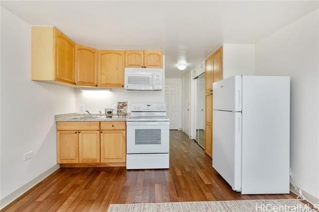 kitchen featuring dark hardwood / wood-style floors, sink, light brown cabinetry, and white appliances