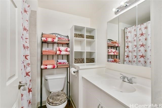 bathroom featuring walk in shower, vanity, and toilet